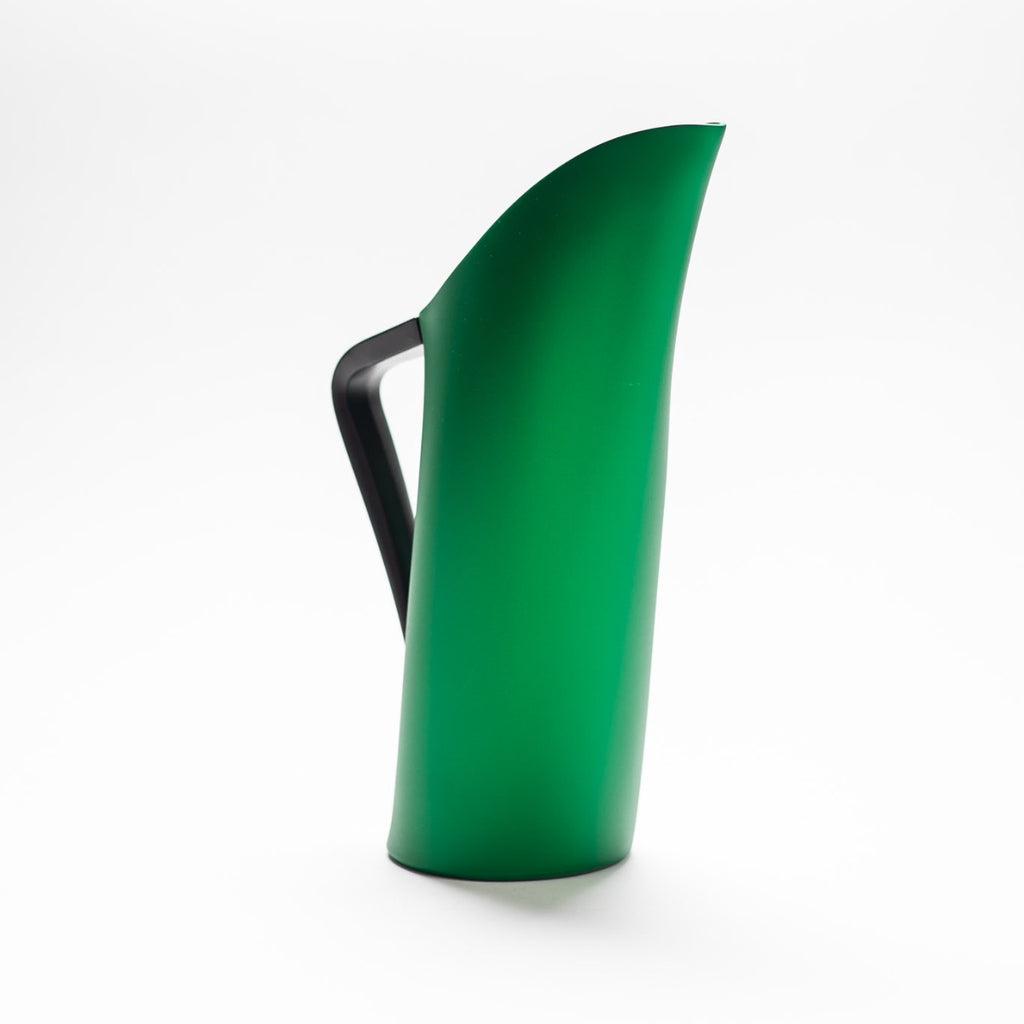 A green matte jug with arched spout seamlessly continuing down to its handle. 