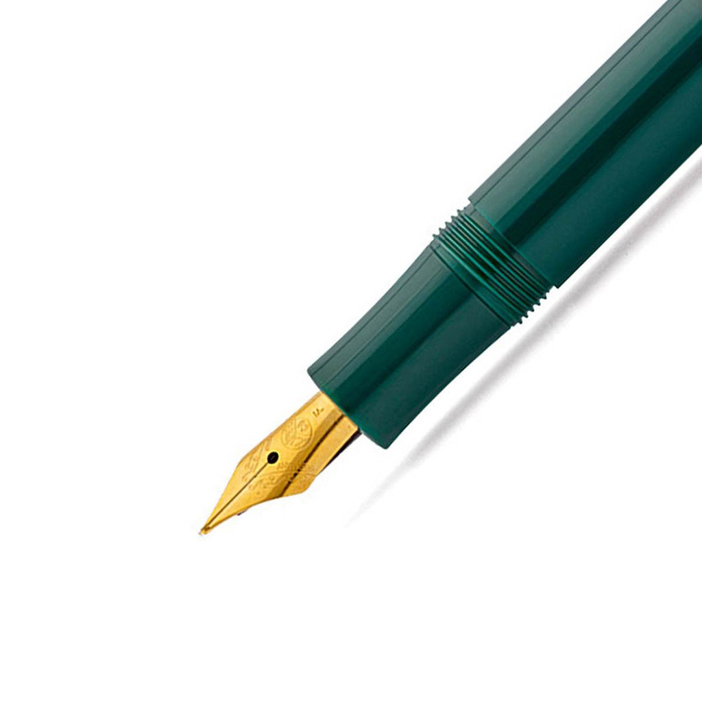 A close up of a fountain gold tip nib on a shiny emerald green pen barrel. 