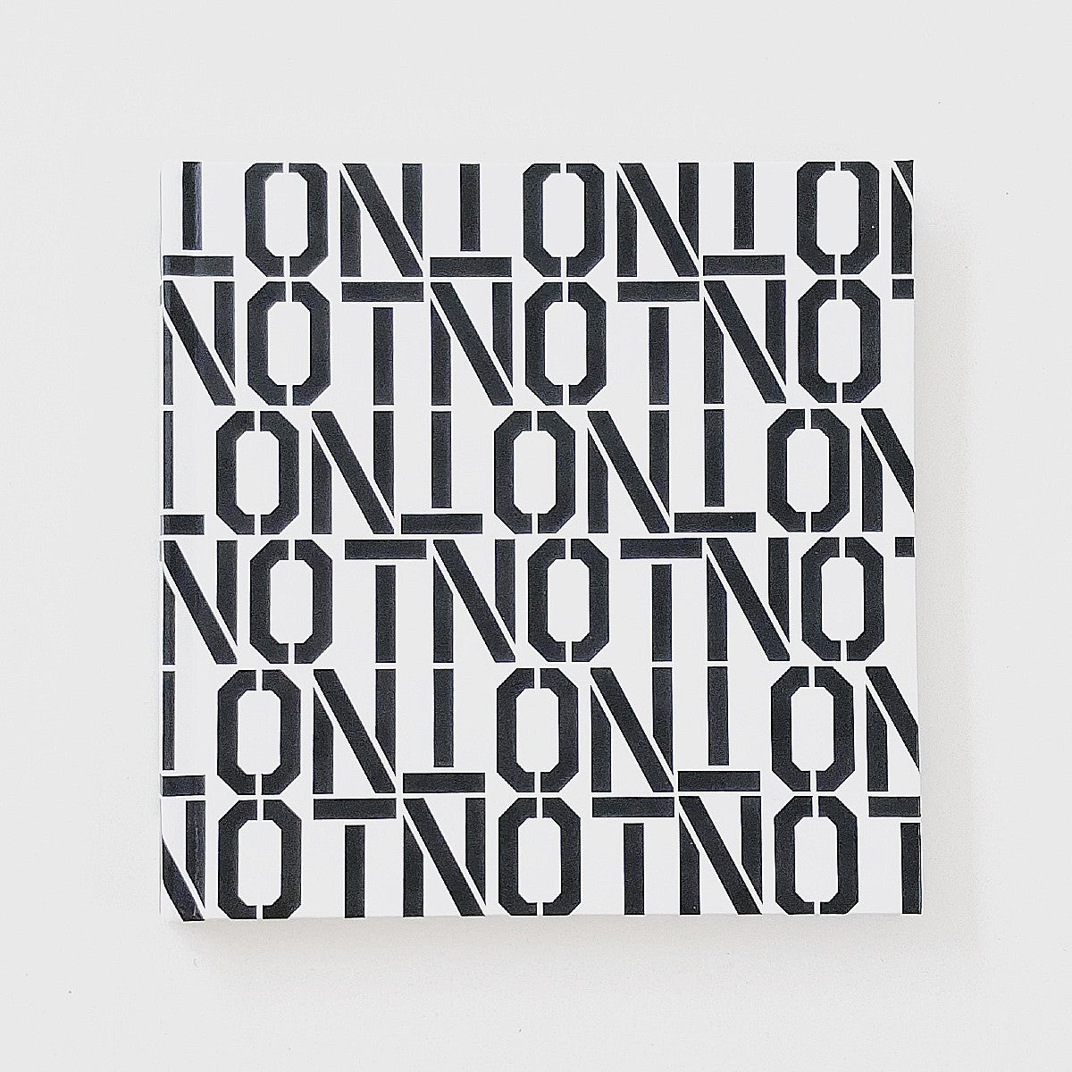 The Cover of the Artists book NOTNOT: Digital Realities by Cam Scott. The cover features repeat block letter that spell "NOT" in black on a white background.