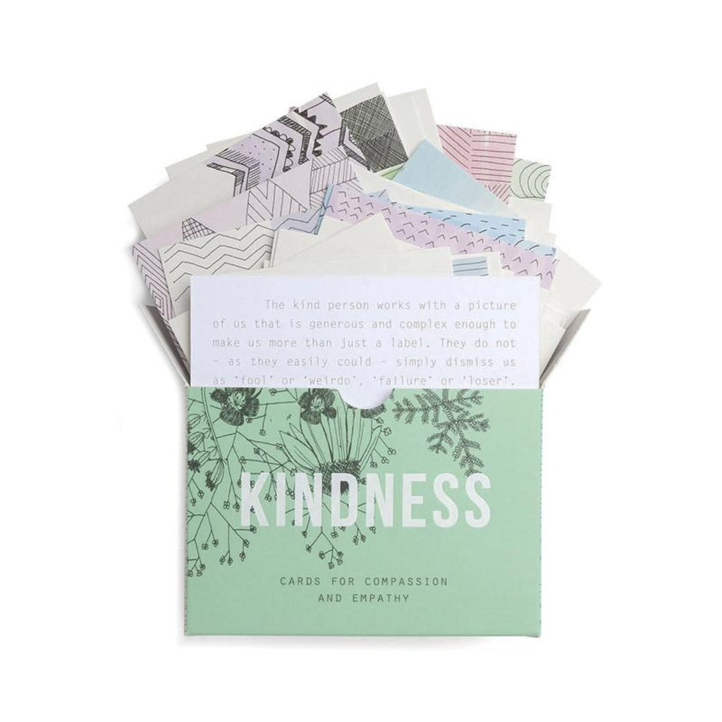 Coming out of the pastel green rectangular box with 'kindness' in the centre are assorted cards with different geometric designs. 