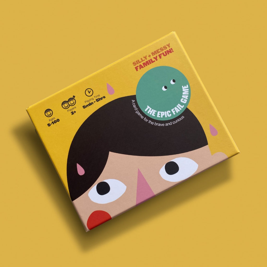 A yellow rectangular box with a green circle over a brunette head looking up lays flat on the matching bright yellow background. 