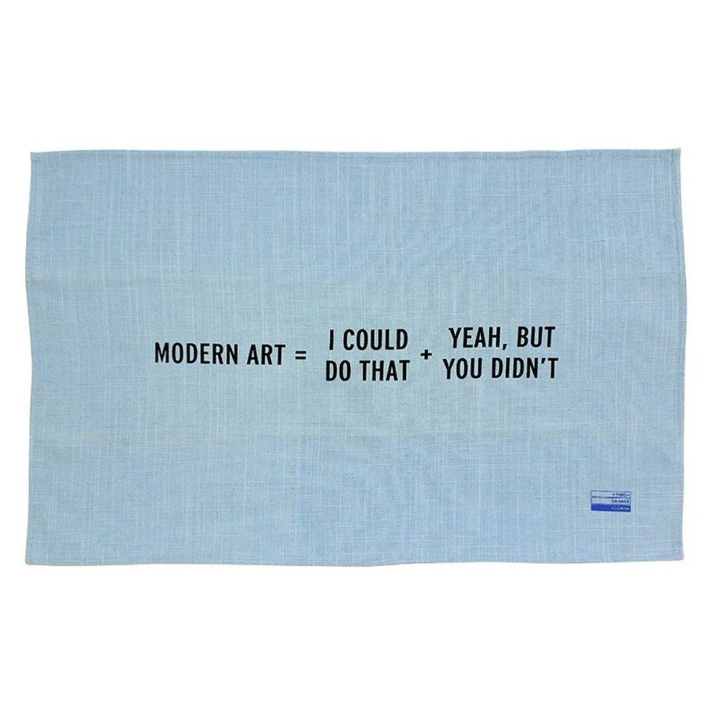 A dove blue tea towel with black capitalised text 'Modern Art = I Could Do That + Yeah, But You Didn't' in the centre. 