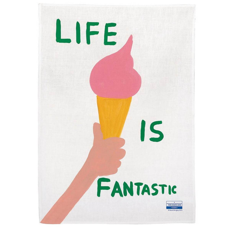 A white tea towel with a hand-painted design of the green capitalised text 'Life is Fantastic' written next to the arm lifting a pink ice cream on a cone. 