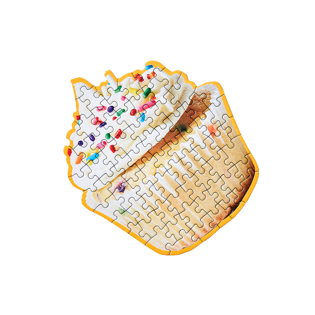 A puzzle in the shape of a cupcake, with icing and rainbow sprinkles