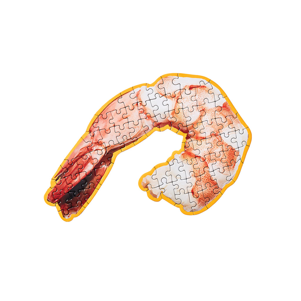 A completed puzzle of a photographed prawn is in the shape of the image with an orange border. 