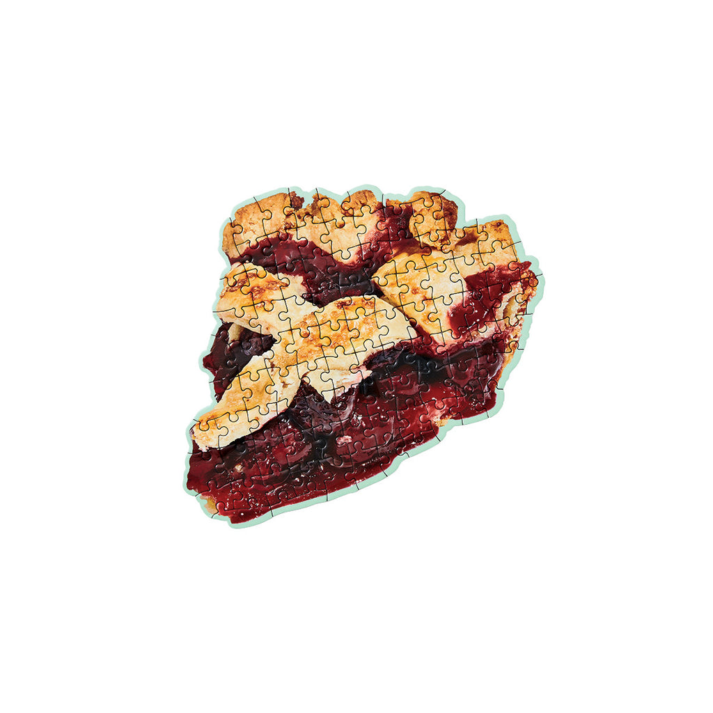 A completed puzzle is in the shape of the photographed slice of American styled cherry pie with a green border. 