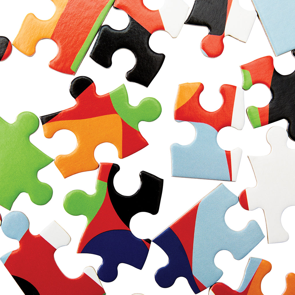 A close up of the puzzle pieces shows each piece have different formless patterns in various colours. 