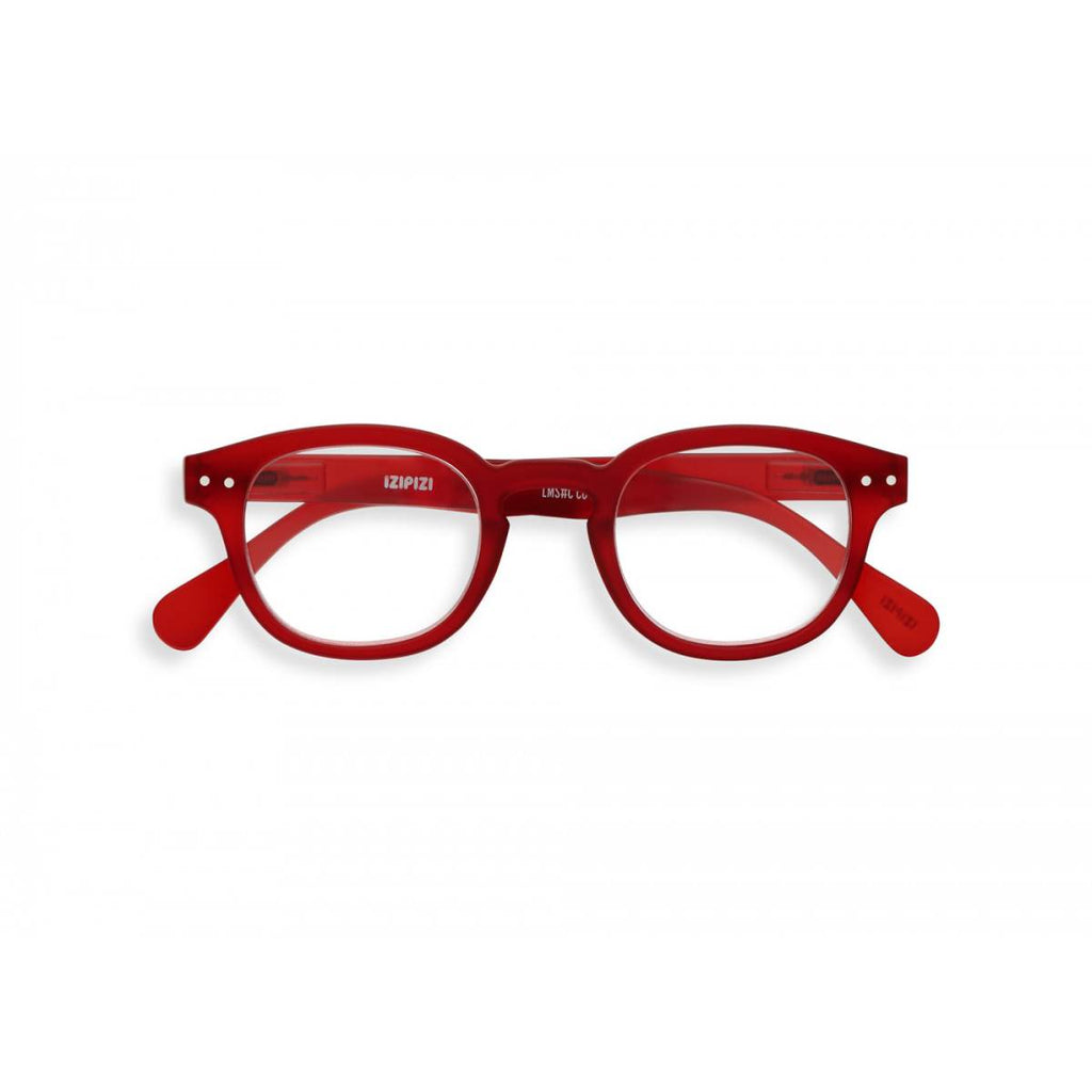 A slightly translucent red pair of magnifying reading glasses. The frames are an stylish, bold, square shape.