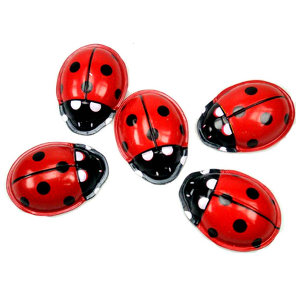 A group of five tin toy ladybirds in red white and black  viewed from above.