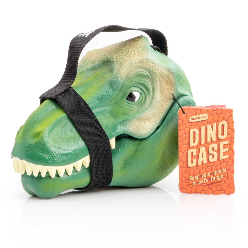 A children's lunch box or storage case in the shape of a Green Tyrannosaurus Rex Head, Shown closed with the carry strap attached, which appears like a harness for the dinosaurs head. Attached tag read " DINO CASE : Keep your goods in safe fangs"