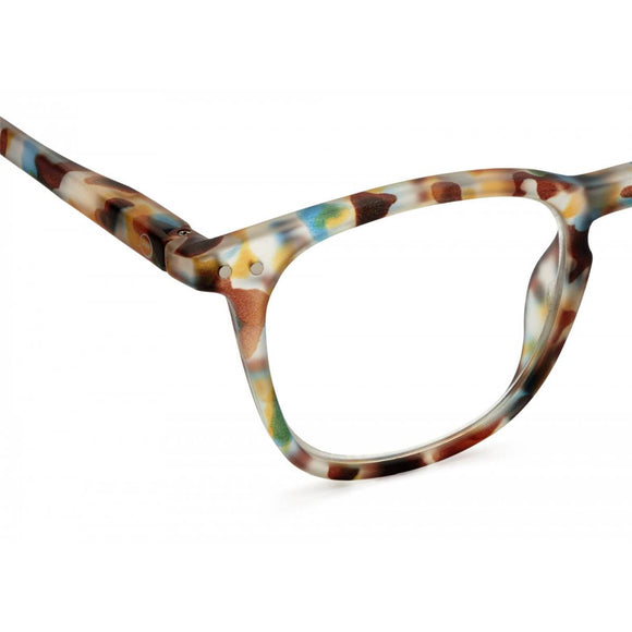 A pair of magnifying reading glasses. The frames are a large, structured, trapezium shape in a mottled blue tortoise shell finish.