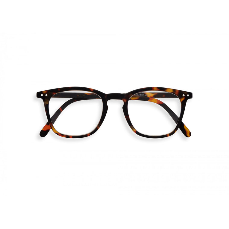 A pair of magnifying reading glasses. The frames are a large, structured, trapezium shape in a mottled classic tortoise shell finish.