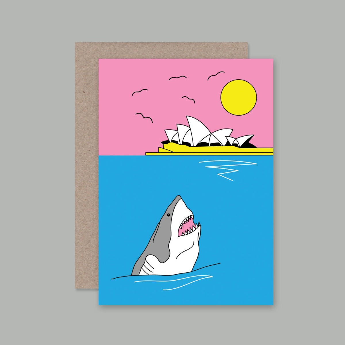 A6 Greeting card featuring an illustration of the sydney harbour with the opera house in the background with the sun and in the front in the ocean features a great white shark