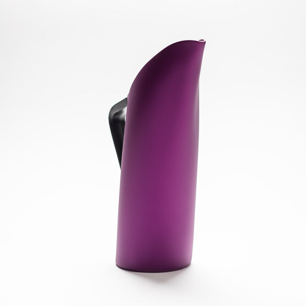 A purple matte jug with arched spout seamlessly continuing down to its handle. 