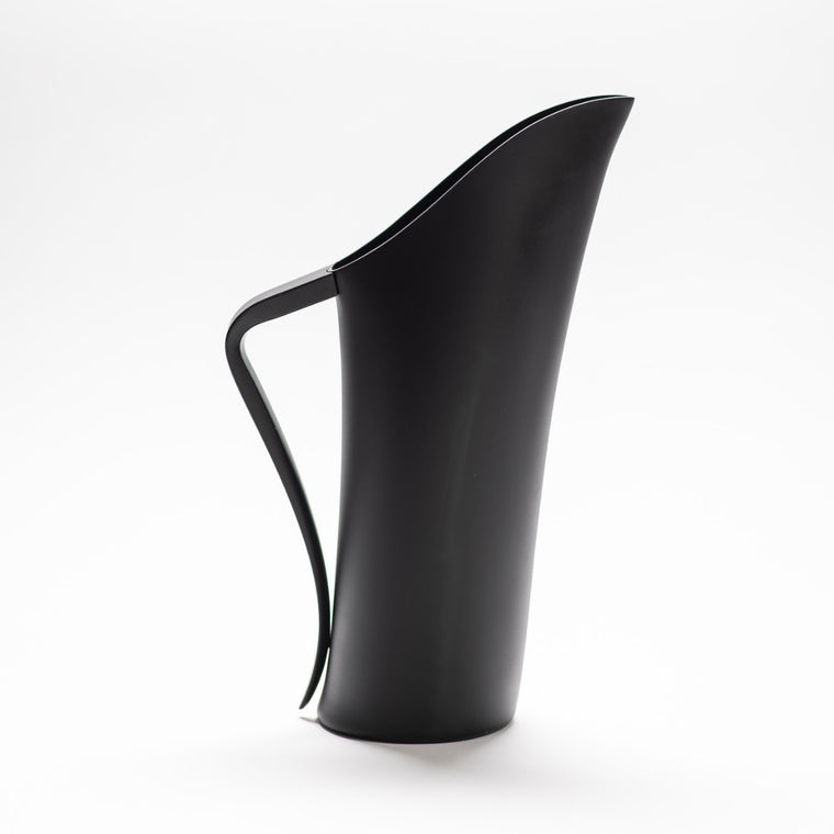A finely designed sculptural black jug made of anodised aluminium.