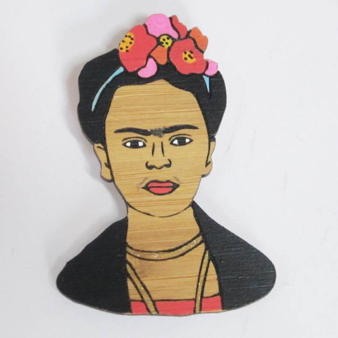 A brooch featuring a portrait of artist Frida Kahlo. Made from bamboo wood and hand painted.