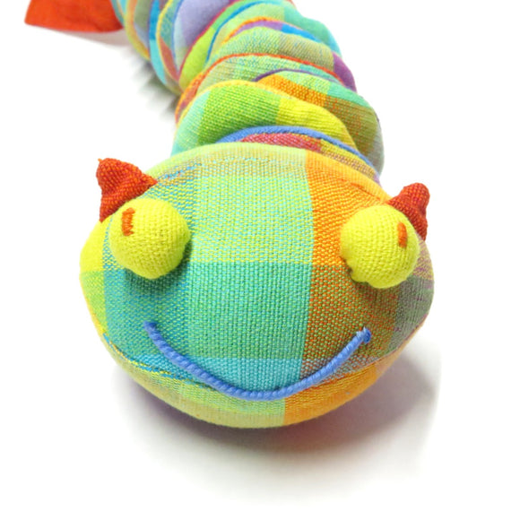 A bright colourful soft toy in the shape of a caterpillar or witchetty grub.
