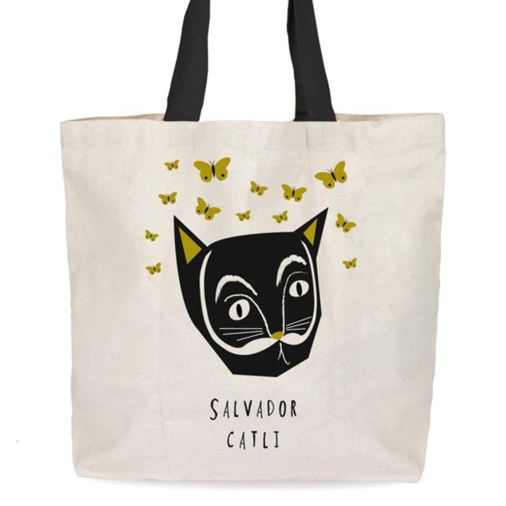 A graphic illustration of yellow butterflies floating around a Salvador Dali-inspired black cat head is on a cream tote bag. 