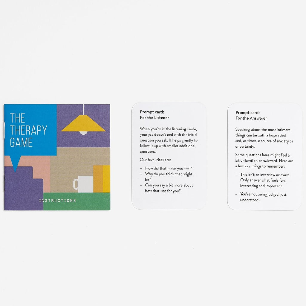 To the right of the colourful geometric designed packaging box of 'The Therapy Game' are two white rectangular cards with black text that says, "Prompt card: For the Listener" on the left and "Prompt card: For the Answerer". 