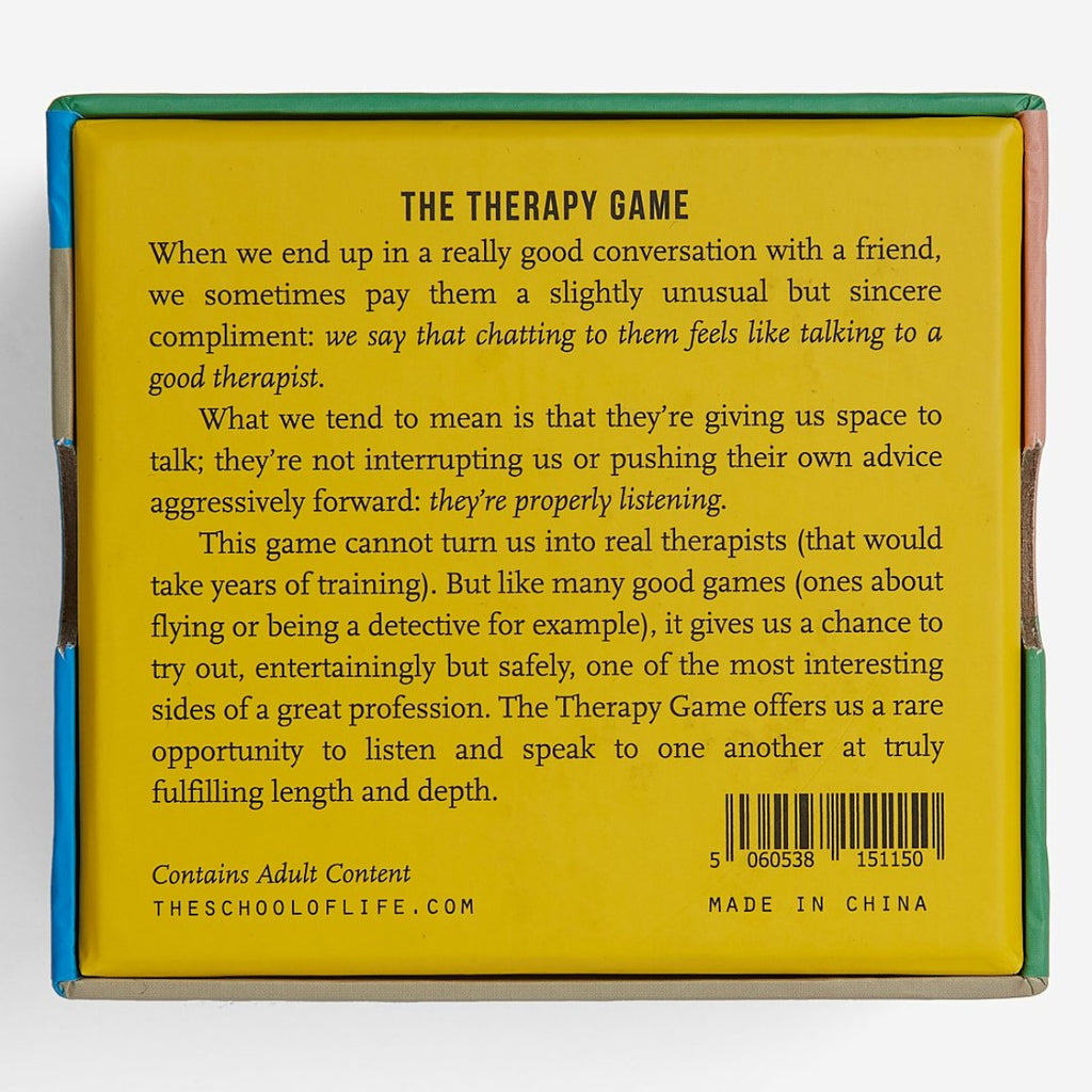 The back of the square packaging box is a yellow background with 'The Therapy Game' blurb in black text. 