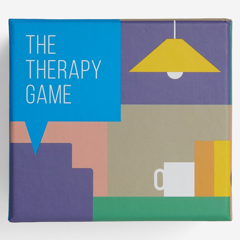 Image featuring a box in the center which includes a blue speech bubble in the left hand corner with the words The Therapy Game which is then surround by a graphically illustrated scene of an office space with a light shade, coffee cup, books and chair