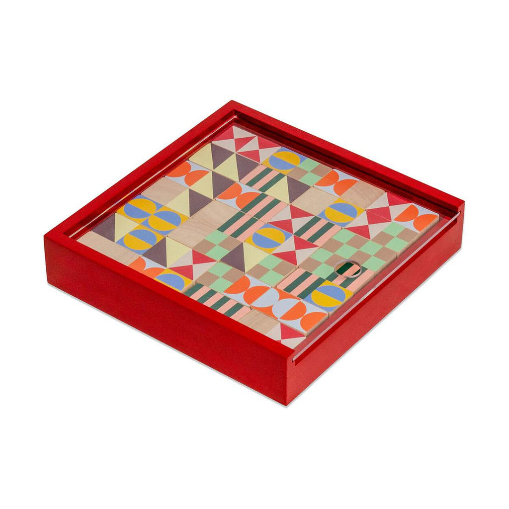 A red wooden box containing a set of wooden dominoes with geometric design.