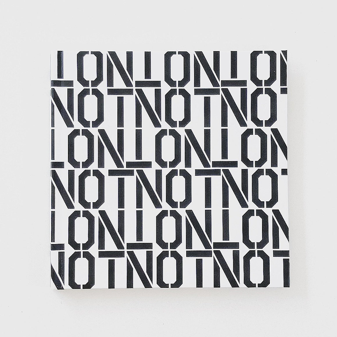 The Cover of the Artists book NOTNOT: Digital Realities by Cam Scott. The cover features repeat block letter that spell "NOT" in black on a white background.