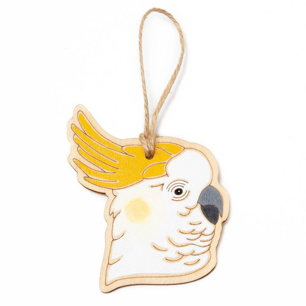 A hanging ornament in the form of a Sulphur-Crested Cockatoo. Laser Etched flat wood is adorned with white, grey, black and yellow hand painting. A Jute string is attached