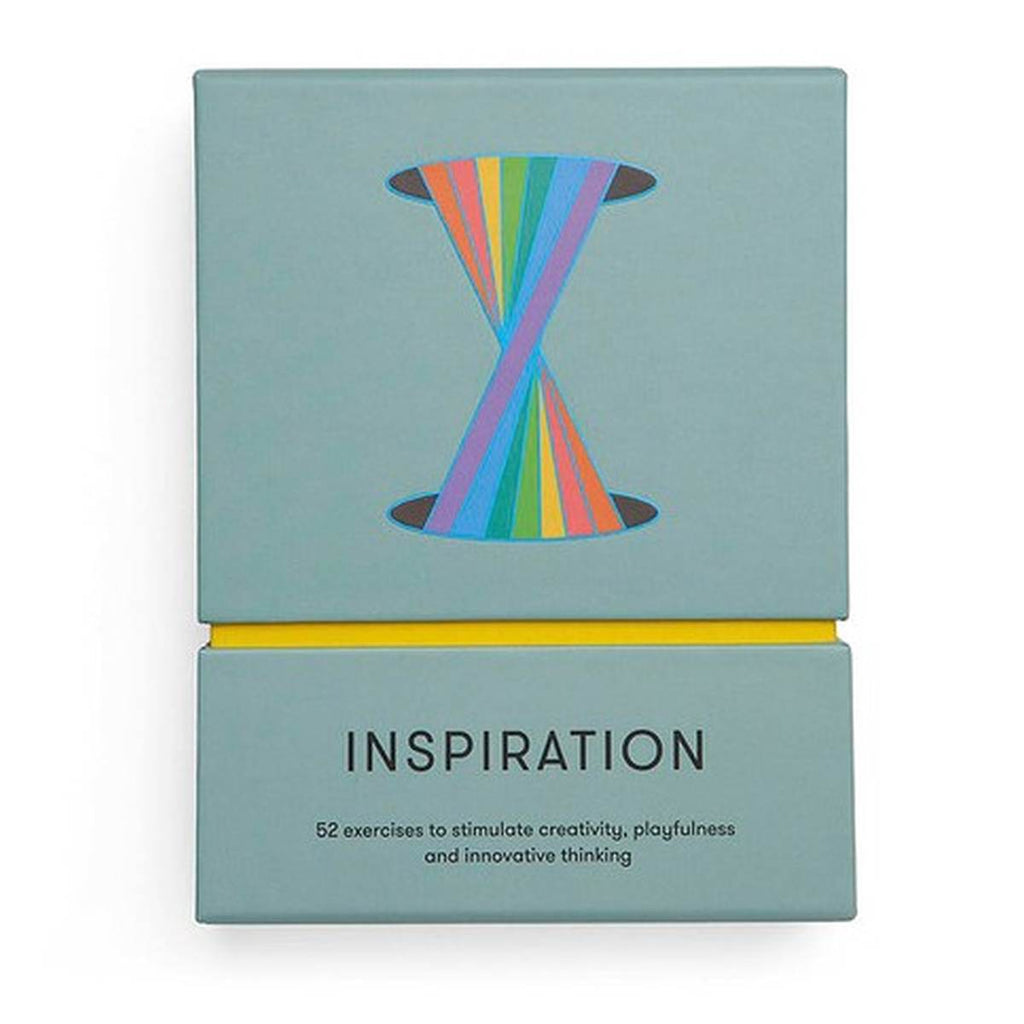 A muted teal rectangular box has a yellow interior that beams between the top and base with 'inspiration' capitalised in black. The top case has a graphic of a vertically stretched rainbow twisted at the centre between two black holes. 