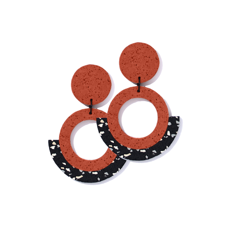 Image of a pair of two earrings which feature a rubberized texture with the colours red, black and white