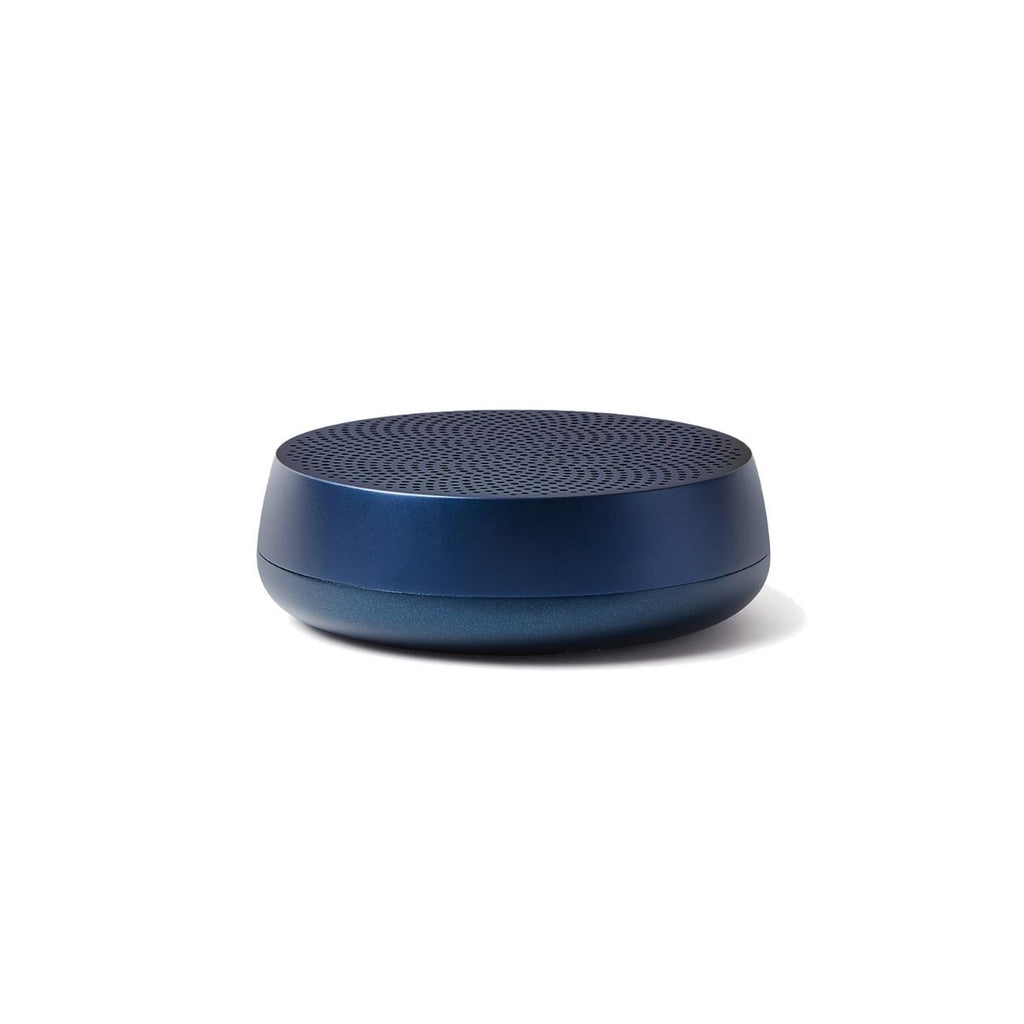 A navy cylindrical speaker with a low profile and a round base. 