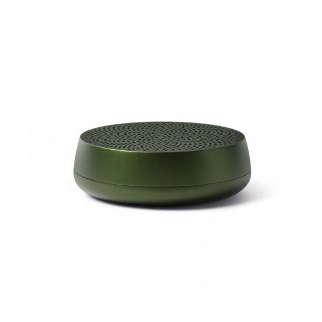 A dark green cylindrical speaker with a low profile and a round base. 