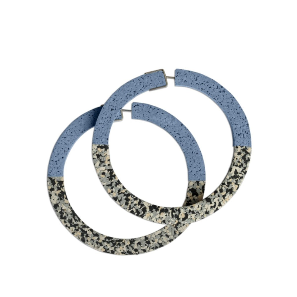 Image of two earrings with a rubberized texture featuring the colours blue, black, white, grey 