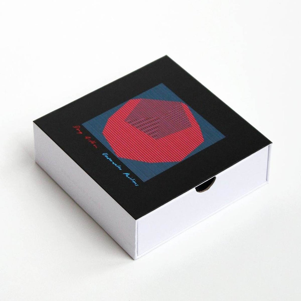 A black top with a graphic design of a 3D red sphere with faceted sides filled with geometric patterned lines inside a blue-lined square of a white box is on a white background. At the bottom of each corner is a handwritten "Doug Aitken" in red on the left and "Underwater Pavilions" in blue on the right.  