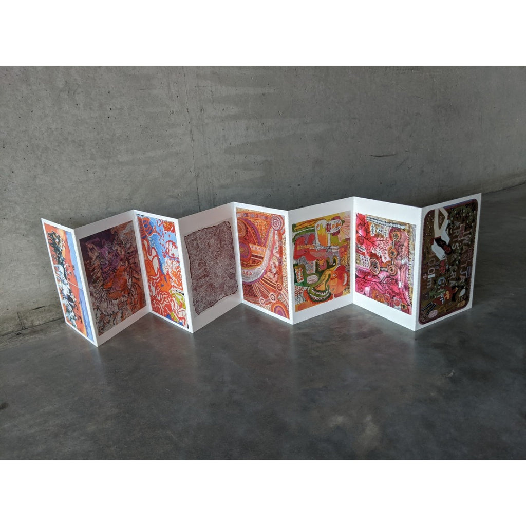 Standing upright on the concrete floor is the vibrant concertina postcards showcasing the different images on each side from various Iwantja Arts artists. 
