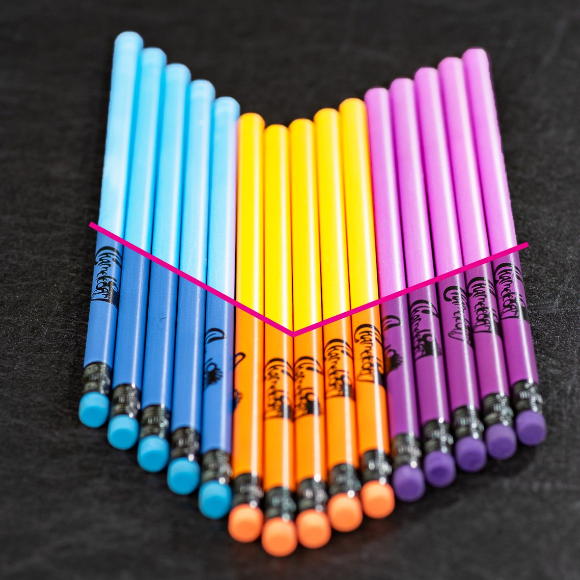 A row of blue, orange and purple pencils with a pink graphic line on the image to distinguish the heat-activated side on the top while the rubber ends remain darker. 