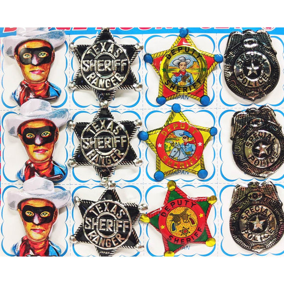A range of brightly coloured wild west themed brooches - including a Lone Ranger, police badge and sheriffs badge - shown on cardboard backing.